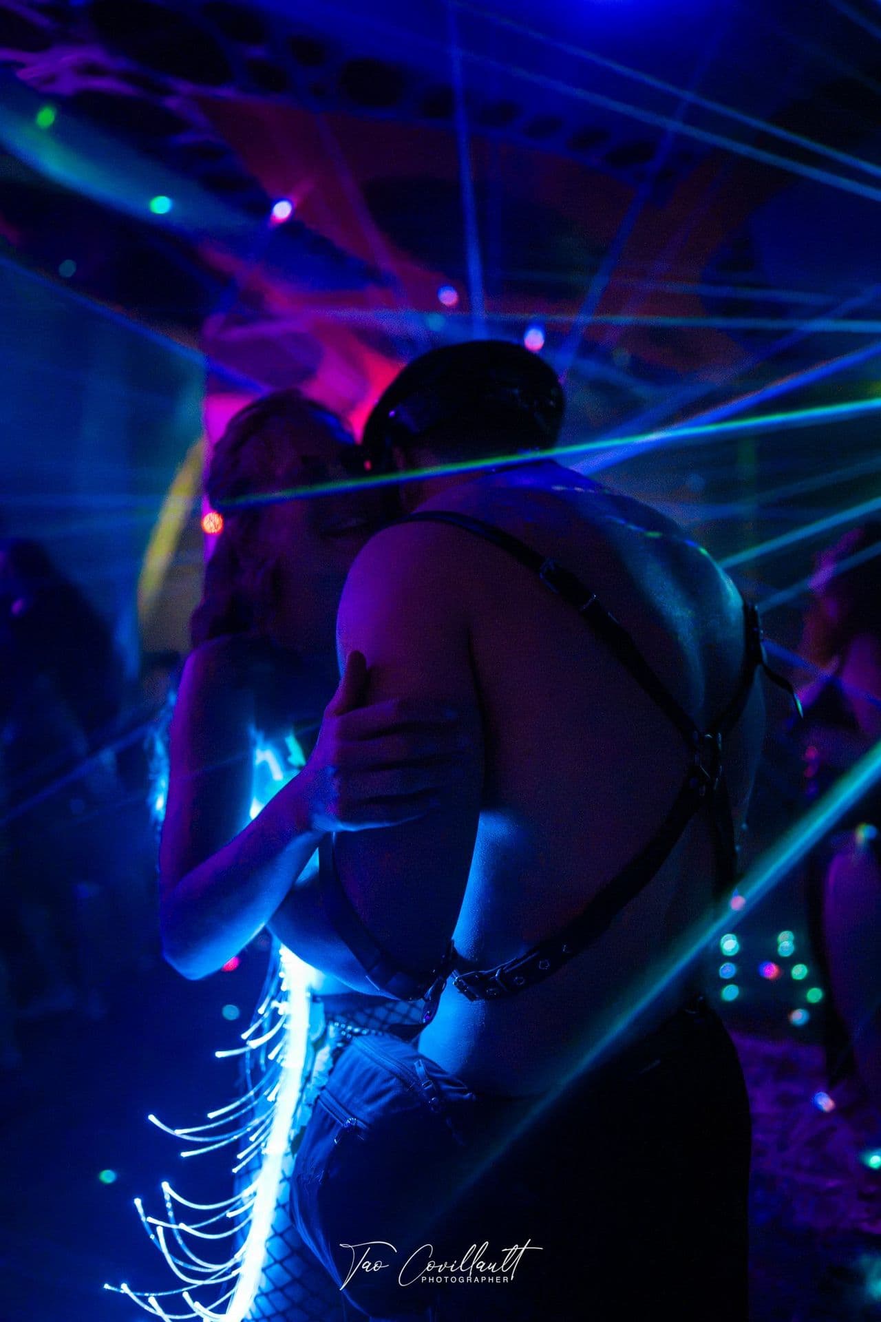 A dancer in a harness moving through blue laser beams